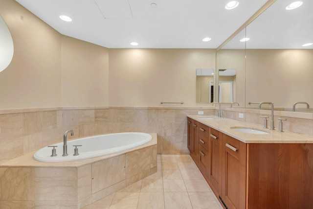 bathroom featuring vanity, tiled bath, and tile walls