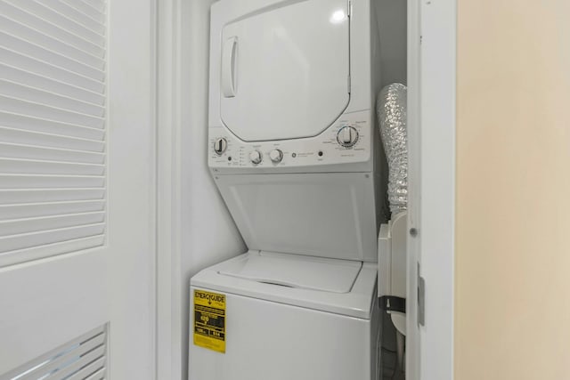 clothes washing area with stacked washer and clothes dryer