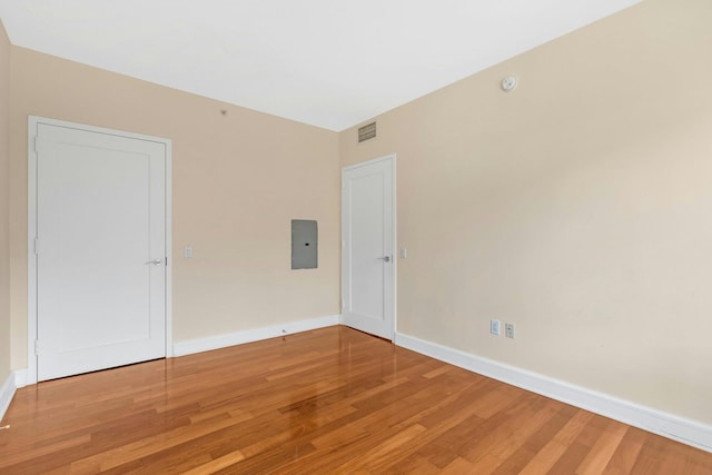 unfurnished room with hardwood / wood-style floors and electric panel