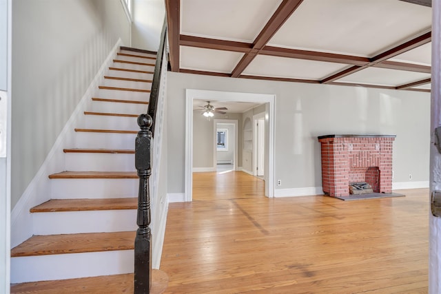 stairway featuring beamed ceiling, hardwood / wood-style flooring, and coffered ceiling