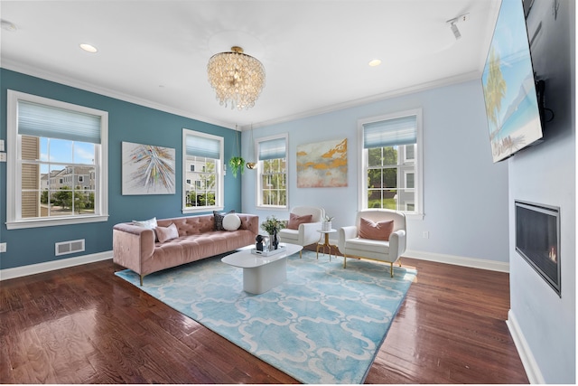 129 Roosevelt Dr, Wood-Ridge, NJ 07075 - living area featuring healthy amount of natural light, crown molding, baseboards, wood finished floors, and a glass covered fireplace