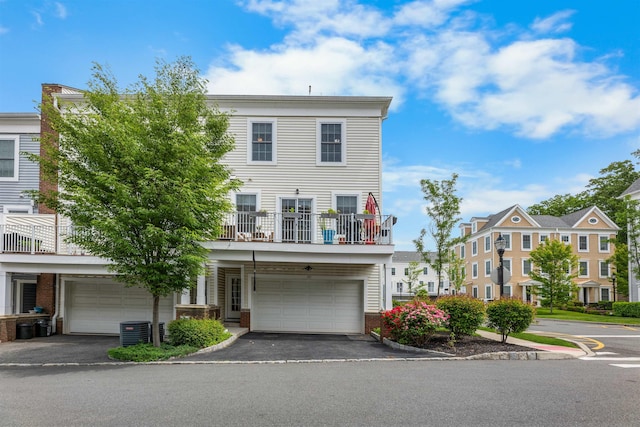 129 Roosevelt Dr, Wood-Ridge, NJ 07075 - multi unit property with asphalt driveway, an attached garage, a balcony, central AC unit, and brick siding