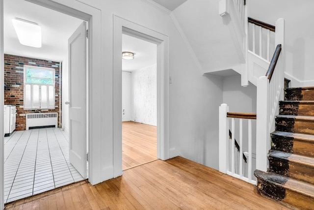 110 56th St, West New York, NJ 07093 - staircase with radiator, hardwood / wood-style flooring, crown molding, and baseboards