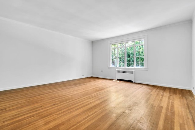 110 56th St, West New York, NJ 07093 - empty room with radiator, light wood-style flooring, crown molding, and baseboards