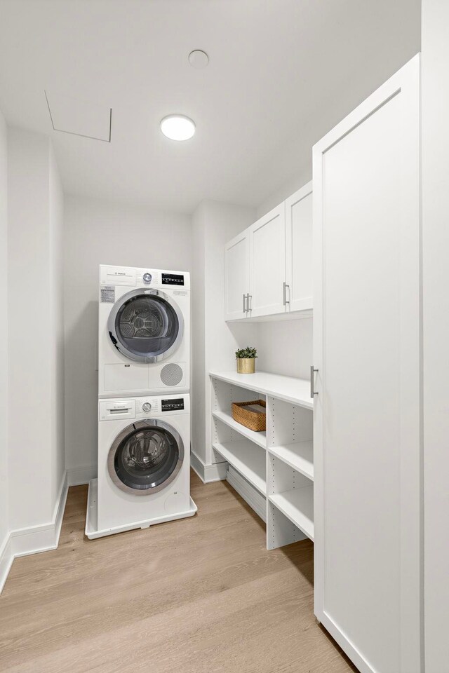 9 Ave At Port Imperial # 524, West New York, NJ 07093 - clothes washing area with stacked washer / drying machine, light wood-style flooring, baseboards, and cabinet space