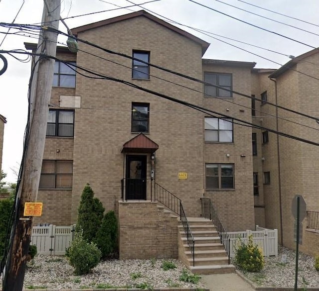 view of front of home with fence and brick siding