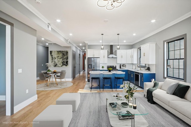 living room with crown molding, sink, and light wood-type flooring