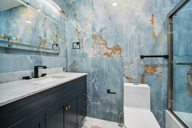 full bathroom with vanity, combined bath / shower with glass door, tile walls, and toilet