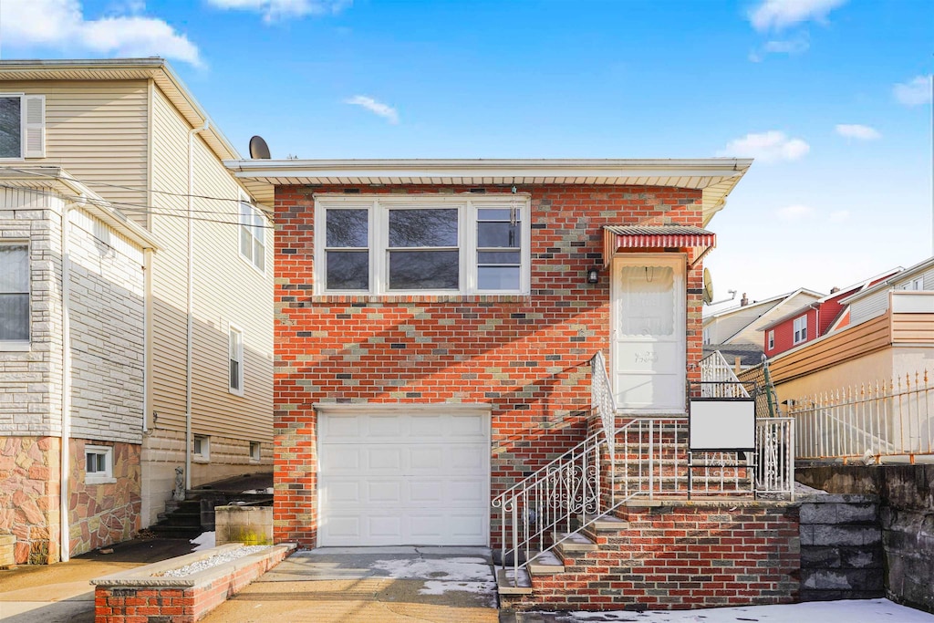 8408 Grand Ave, North Bergen, NJ 07047 - view of front of house with an attached garage, stairway, brick siding, and driveway