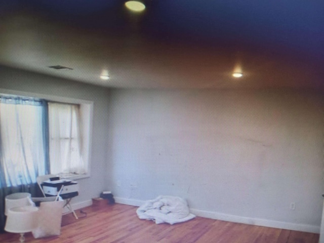 empty room featuring baseboards and wood finished floors