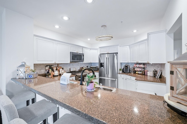 319 The Promenade, Edgewater, NJ 07020 - kitchen featuring appliances with stainless steel finishes, white cabinets, recessed lighting, and backsplash