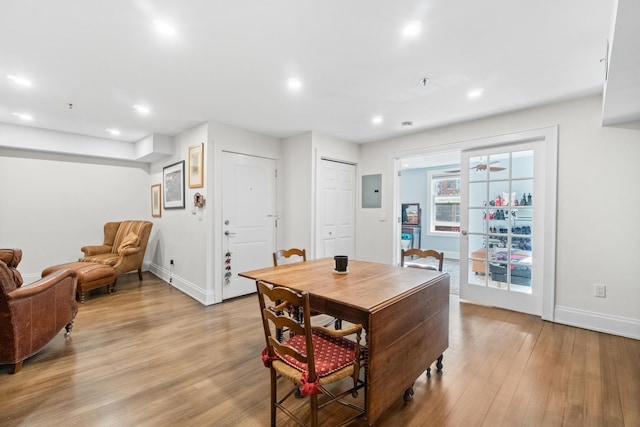 dining space featuring electric panel and light hardwood / wood-style flooring