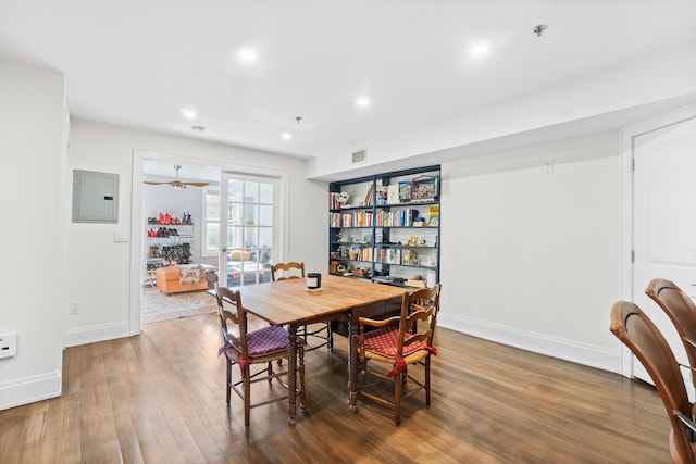 dining space with hardwood / wood-style flooring and electric panel