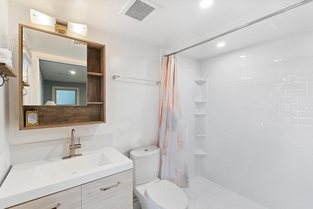 bathroom featuring vanity, walk in shower, and toilet