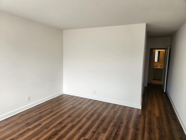 empty room with baseboards and dark wood-style flooring