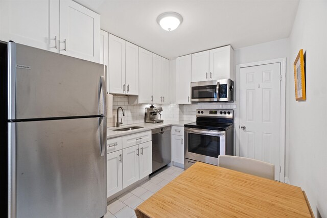 607 1st St Unit 2F, Hoboken, NJ 07030 - kitchen featuring light countertops, white cabinets, decorative backsplash, stainless steel appliances, and a sink