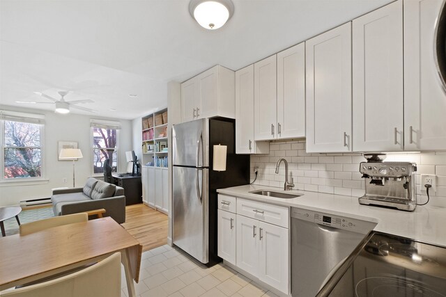 607 1st St Unit 2F, Hoboken, NJ 07030 - kitchen featuring white cabinets, light countertops, a sink, stainless steel appliances, and decorative backsplash