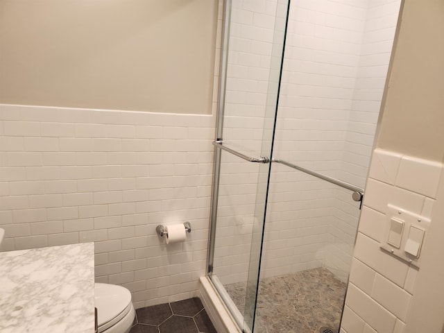 86 W 33rd St Unit 207, Bayonne, NJ 07002 - bathroom with tile walls, a tile shower, wainscoting, tile patterned floors, and vanity