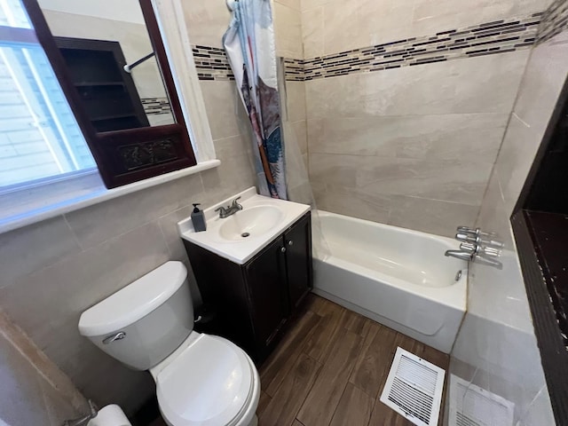 full bathroom with wood-type flooring, toilet, shower / tub combo with curtain, vanity, and tile walls