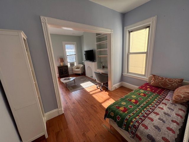 bedroom featuring hardwood / wood-style floors and cooling unit