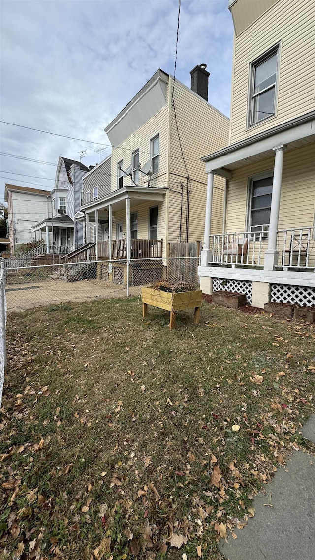 back of house featuring a porch and a yard