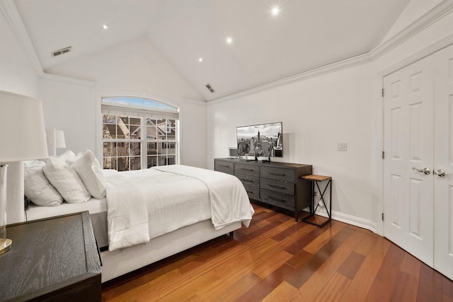 bedroom featuring lofted ceiling, visible vents, wood finished floors, and ornamental molding