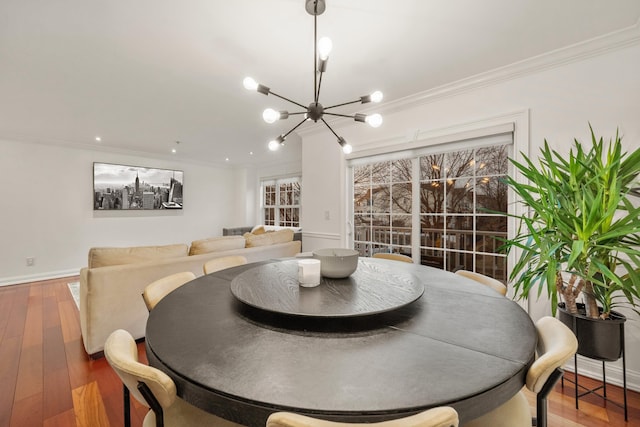 dining room featuring baseboards, a notable chandelier, ornamental molding, and wood finished floors