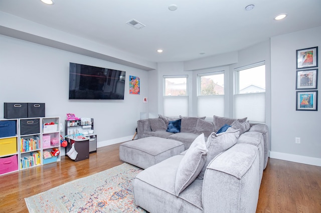 living area with recessed lighting, wood finished floors, visible vents, and baseboards