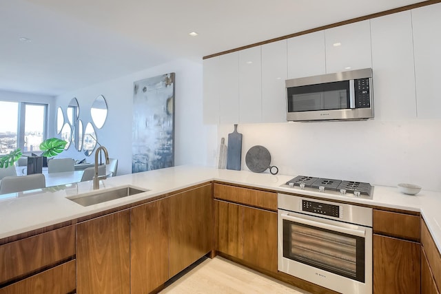 75 Park Ln S Unit 3202, Jersey City, NJ 07310 - kitchen featuring stainless steel appliances, light countertops, white cabinets, brown cabinets, and modern cabinets