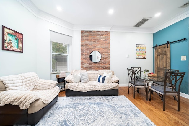 living room featuring crown molding, a barn door, and hardwood / wood-style floors