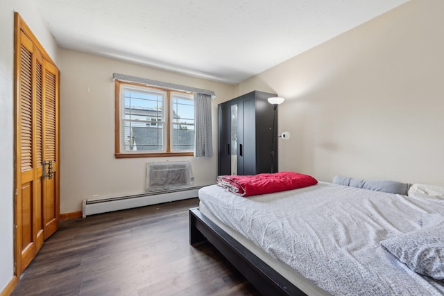 711 Humboldt St, Secaucus, NJ 07094 - bedroom featuring a baseboard heating unit, dark wood-type flooring, a wall mounted AC, baseboards, and a closet
