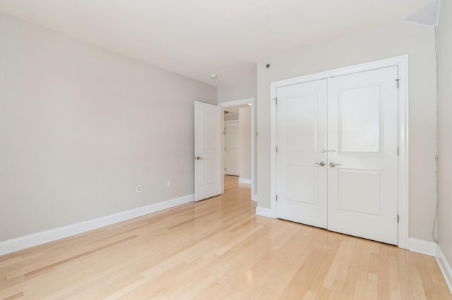 unfurnished bedroom with a closet and light wood-type flooring