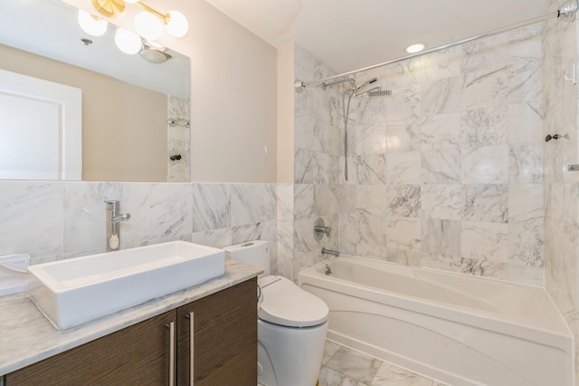 full bathroom featuring vanity, tiled shower / bath combo, tile walls, and toilet