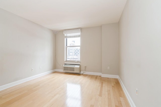 unfurnished room featuring light hardwood / wood-style flooring and a wall unit AC