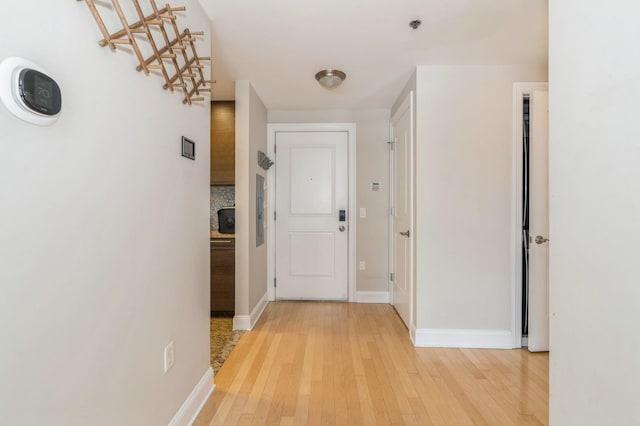 hallway with light hardwood / wood-style floors and electric panel