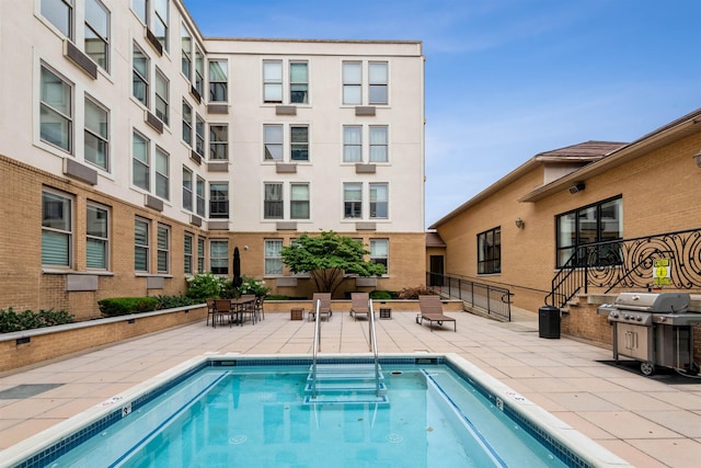 view of pool with grilling area and a patio