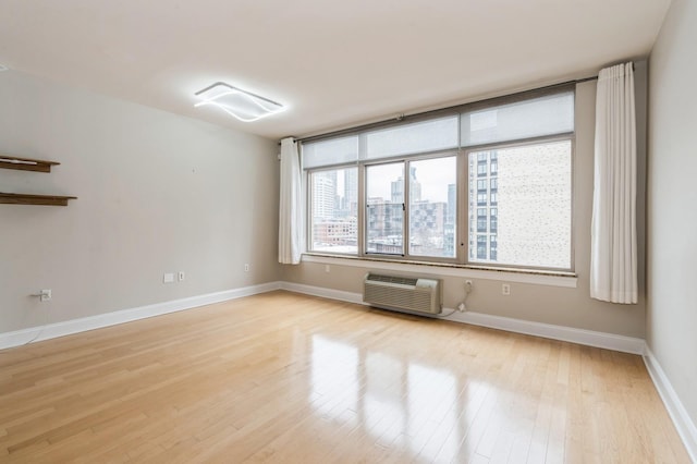 unfurnished room featuring light hardwood / wood-style flooring and a wall mounted AC