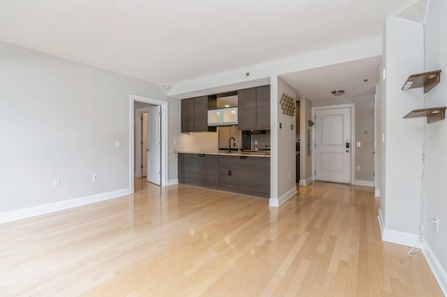 unfurnished living room with sink and light hardwood / wood-style flooring