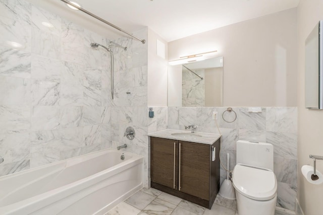 full bathroom featuring tiled shower / bath combo, vanity, tile walls, and toilet