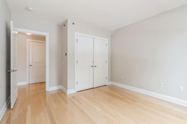 unfurnished bedroom with a closet and light wood-type flooring