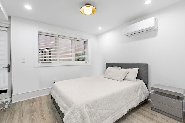 121 Coles St Unit 1, Jersey City, NJ 07306 - bedroom with a wall mounted AC, wood finished floors, recessed lighting, and baseboards