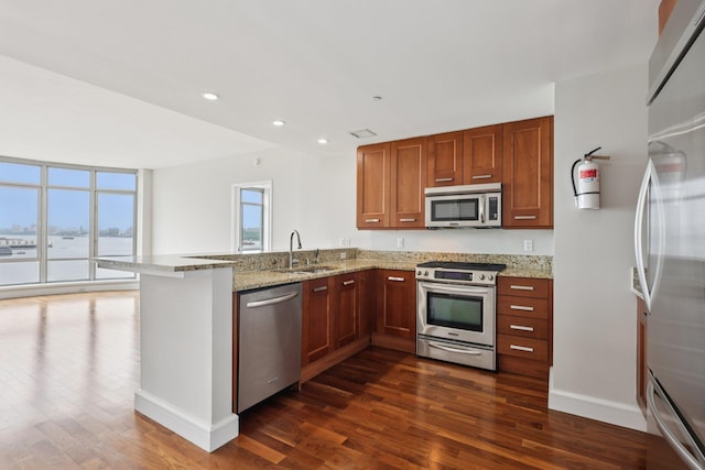 8100 River Rd Unit 1215, North Bergen, NJ 07047 - kitchen with stainless steel appliances, dark wood finished floors, a peninsula, light stone counters, and recessed lighting