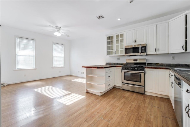 kitchen featuring white cabinets, light hardwood / wood-style floors, and appliances with stainless steel finishes