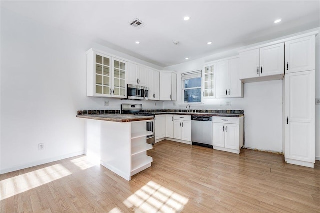 kitchen featuring stainless steel appliances, white cabinetry, and light hardwood / wood-style flooring