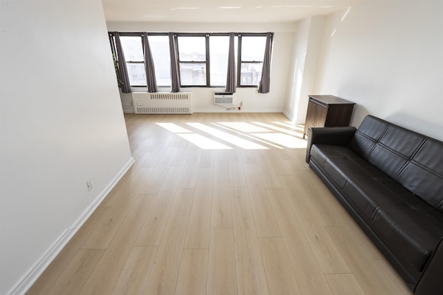 500 Central Ave Unit 520, Union City, NJ 07087 - living room featuring a wall mounted air conditioner, radiator, baseboards, and light wood-type flooring