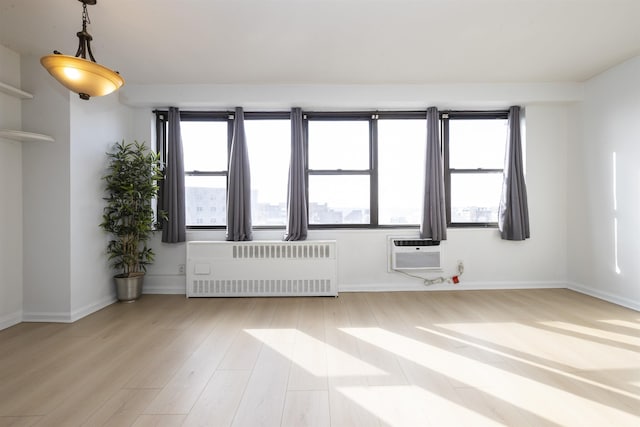 500 Central Ave Unit 520, Union City, NJ 07087 - empty room with baseboards, radiator heating unit, light wood finished floors, and a wall mounted AC