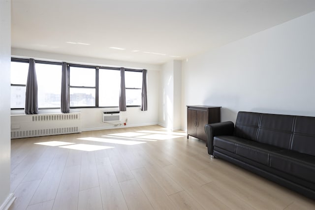 500 Central Ave Unit 520, Union City, NJ 07087 - living room featuring a wall mounted AC, radiator heating unit, baseboards, and wood finished floors