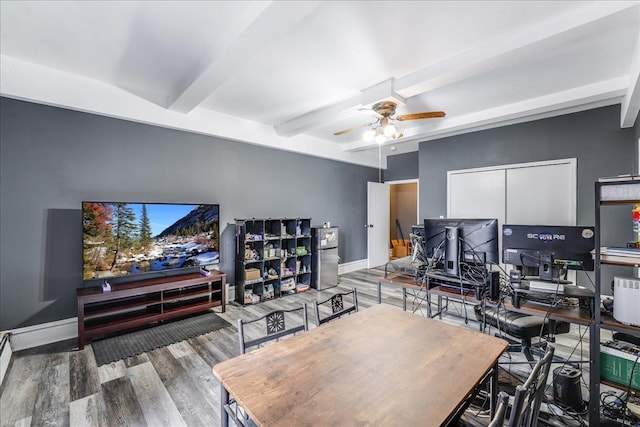 office space featuring beamed ceiling, wood finished floors, a ceiling fan, and baseboards