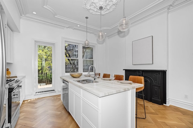 kitchen featuring sink, appliances with stainless steel finishes, a kitchen island with sink, white cabinetry, and a kitchen bar