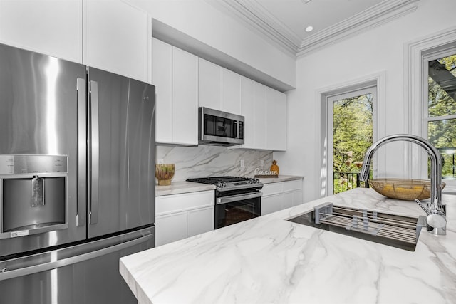 kitchen featuring light stone counters, tasteful backsplash, stainless steel appliances, and white cabinets